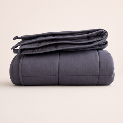 Folded dark gray weighted blanket on a beige background
